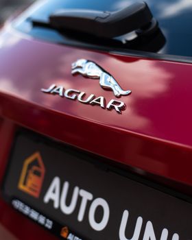 Stylish close-up of a Jaguar car logo reflecting a luxurious brand image. 12175810