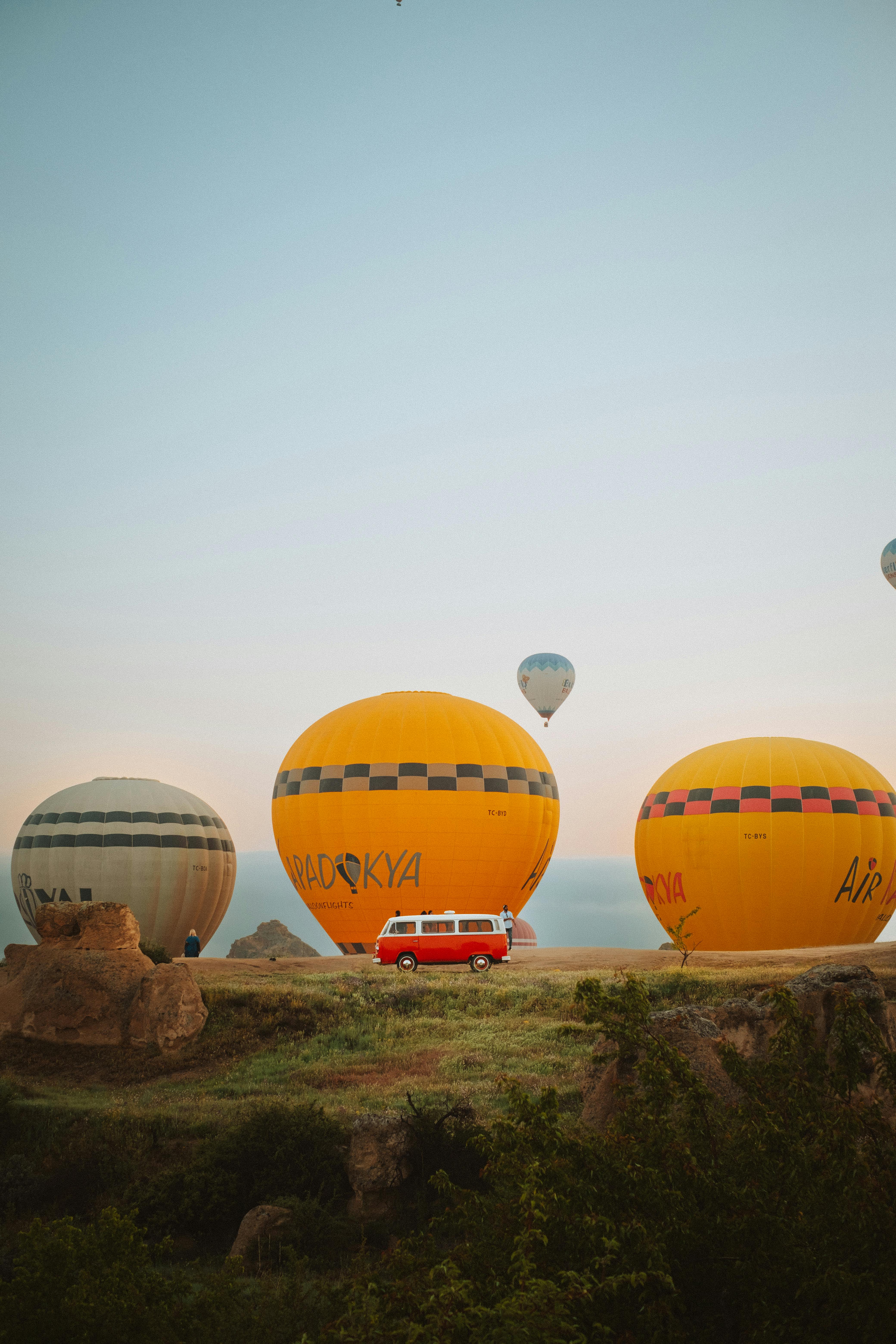 red van and hot air balloons at sunrise