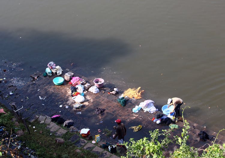 Man Washing Clothes By The River 