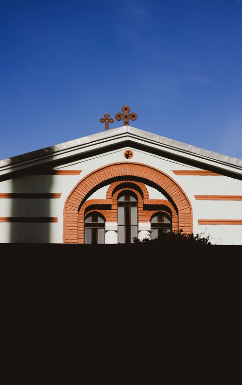 Free Capture of a historic church facade in Istanbul, featuring decorative crosses against a blue sky. Stock Photo
