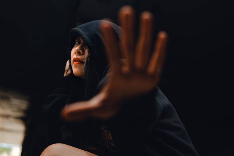 Girl In Hoodie Stretching Palm To Camera