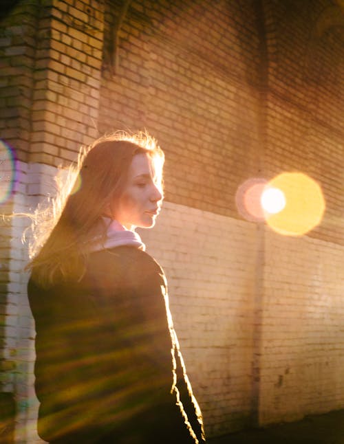 Beautiful Woman Walking by the Brick Wall