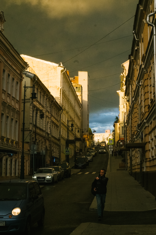 Free A moody urban street scene at dusk with dramatic clouds and vintage architecture. Stock Photo