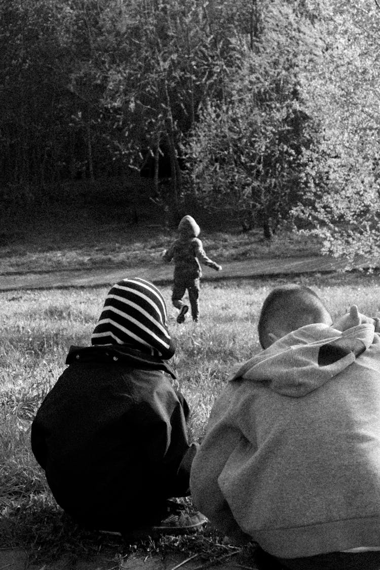 Black And White Photo Of Kids Sitting On The Grass