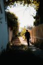 Man in Black Jacket Walking on Sidewalk