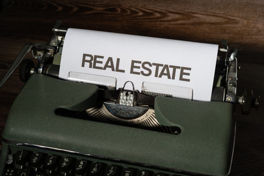 Close-up of a retro typewriter with 'Real Estate' text on paper.
