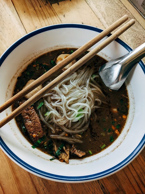 A Pair of Wooden Chopsticks on a Bowl of Noodles 