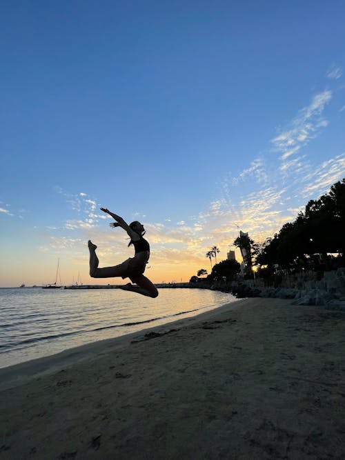 Woman Jumping on the Beach during Sunset