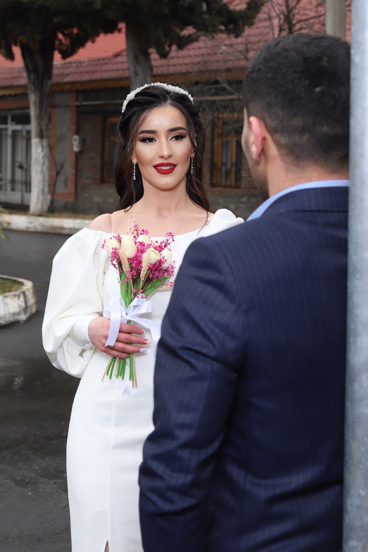 Beautiful Woman Holding Flowers In Front Of A Man