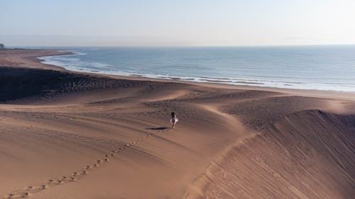 Woman Walking on the Sand in the Beach