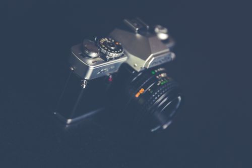 Free A close-up of a vintage film camera with a classic lens, showcasing a retro design on a dark background. Stock Photo