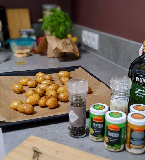 Free Golden potatoes prepared with spices on a baking sheet, ready for roasting. Stock Photo