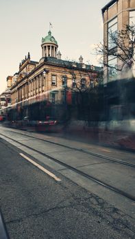 Long exposure of a historic building with a blurred streetcar passing by in downtown Toronto, Canada.