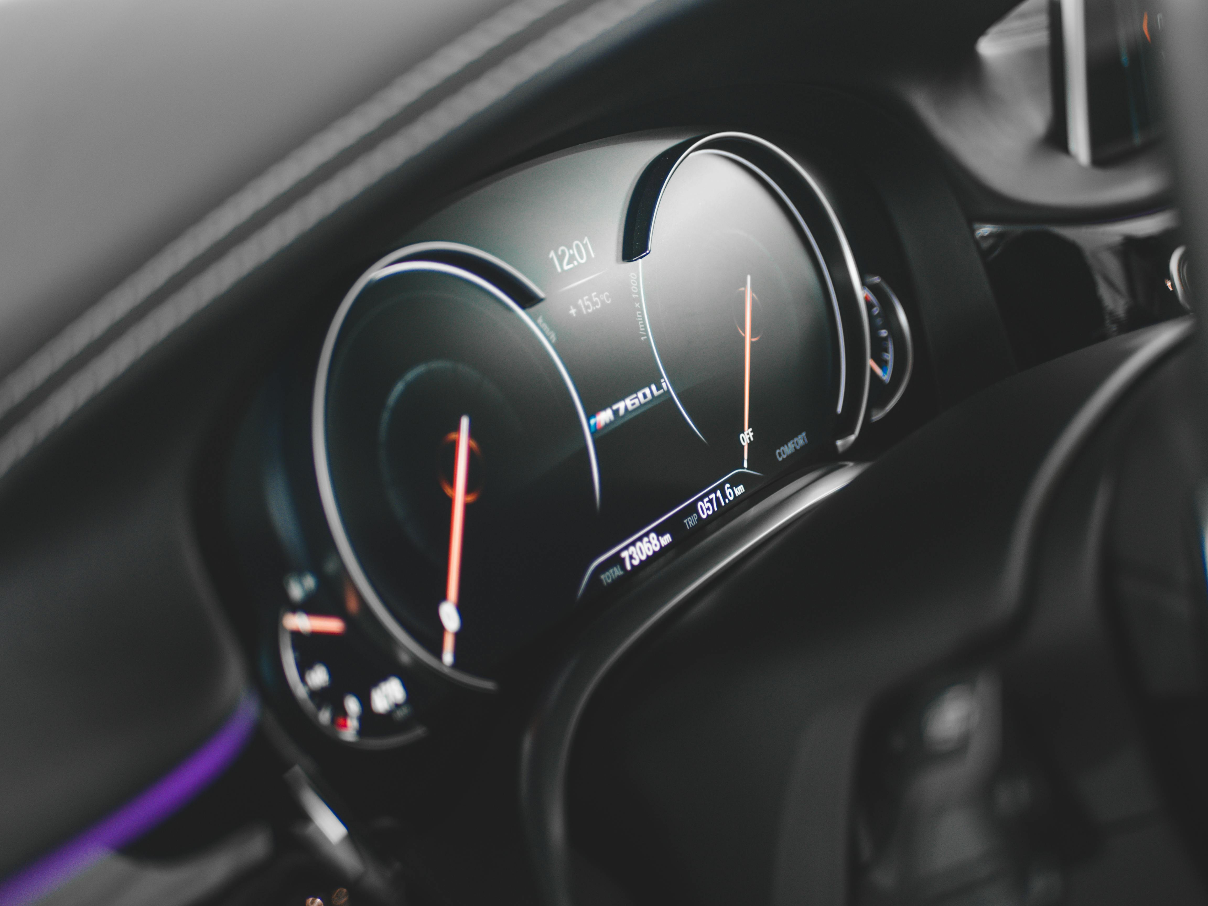 Close-up view of a sleek digital car dashboard featuring a modern speedometer and tachometer.