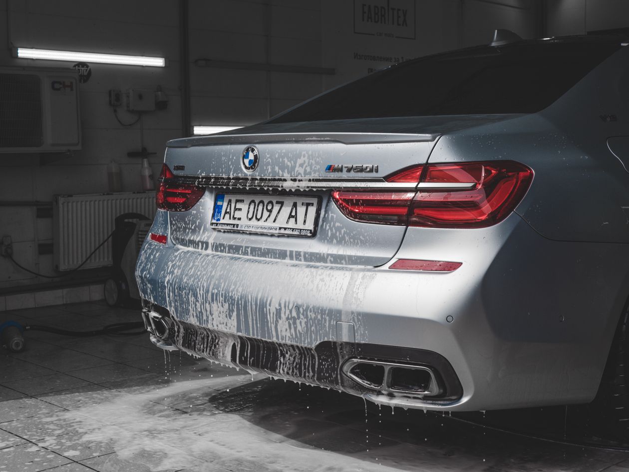 Rear of a car being rinsed with foam and water at a wash station