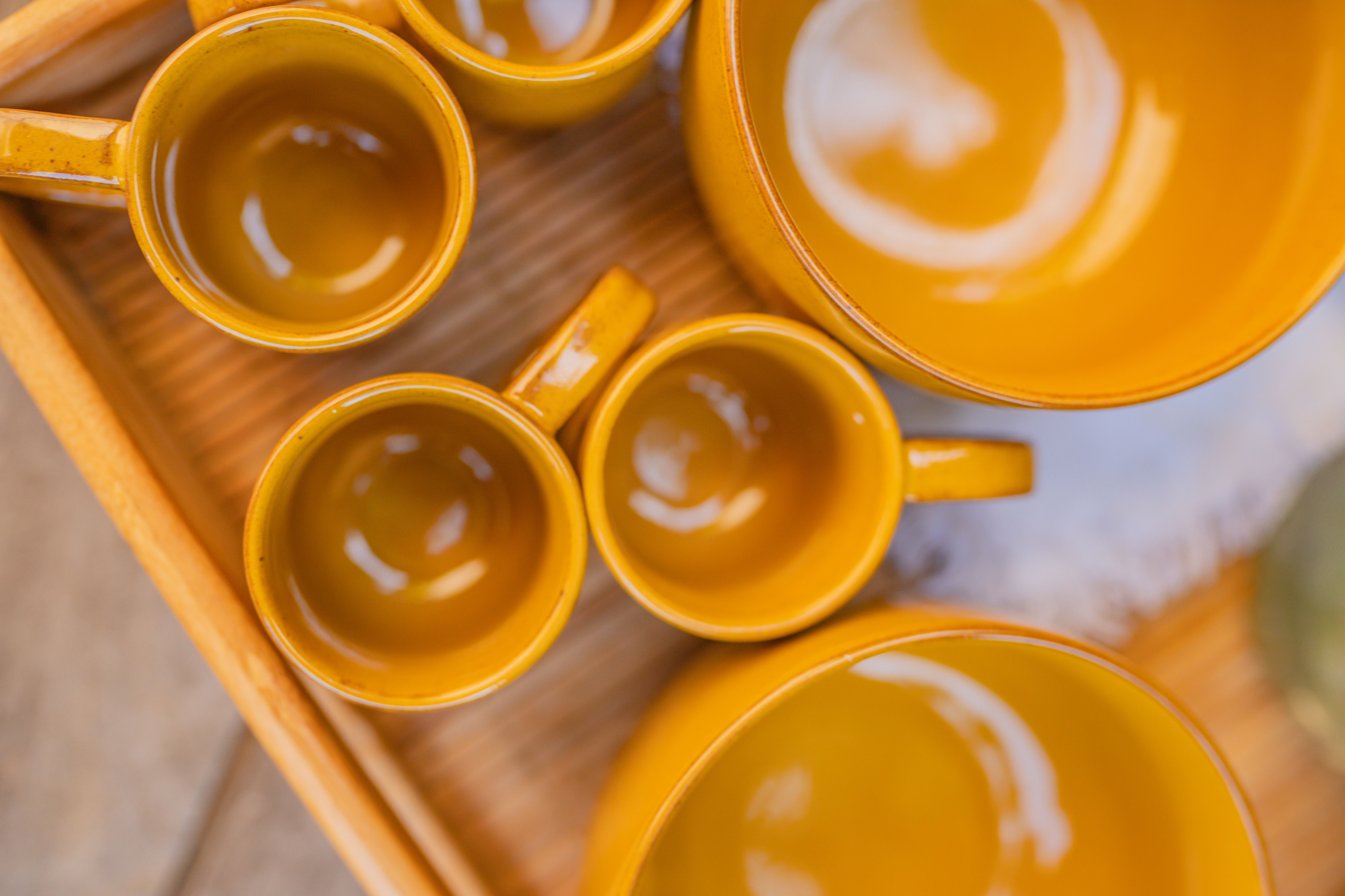 mugs and bowls angled face down in the top rack of an open dishwasher