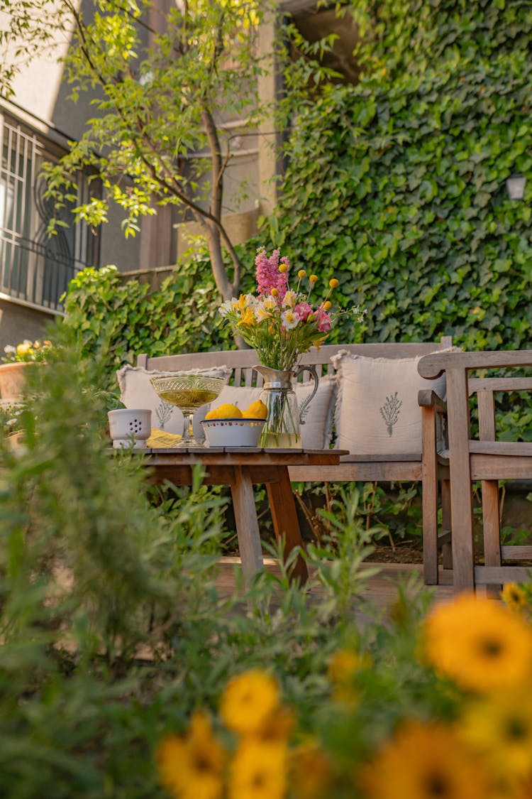 Flowers In Vase On Table In Garden