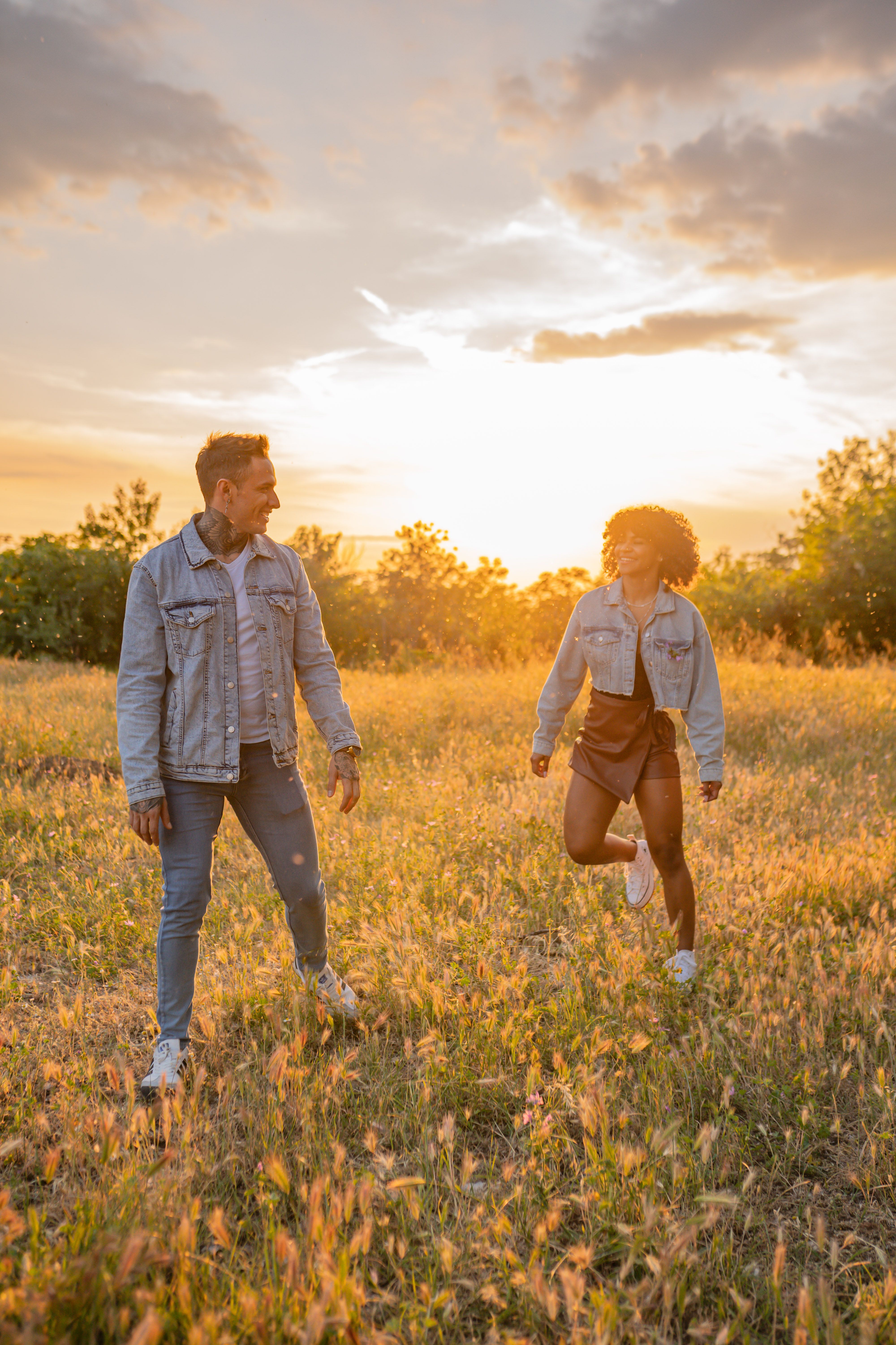 A Couple Wearing Denim Jackets Standing on Grass Field · Free Stock Photo