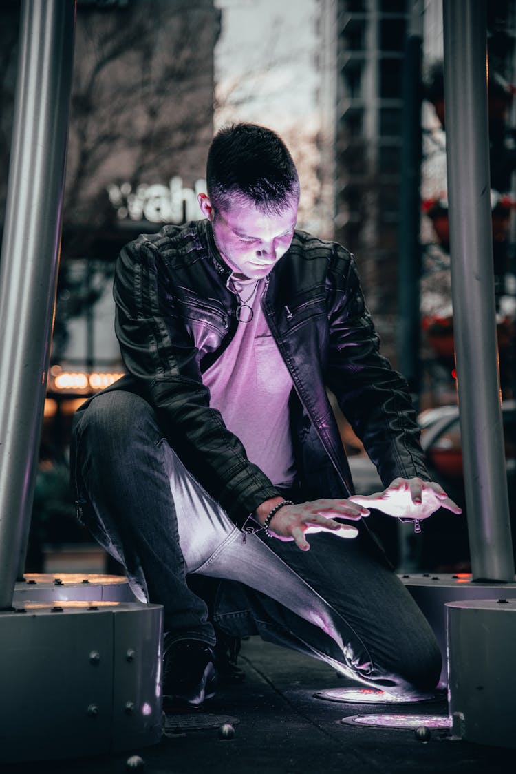 A Man Kneeling By A Light