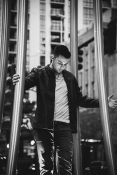 Black and white portrait of a man standing among urban architecture.
