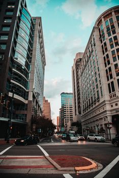 Vibrant city street surrounded by towering high rises and bustling urban life during the day.