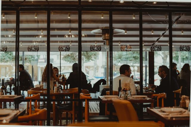 Dining room seen through glass at dusk. Photo by Cihan Yüce on Pexels