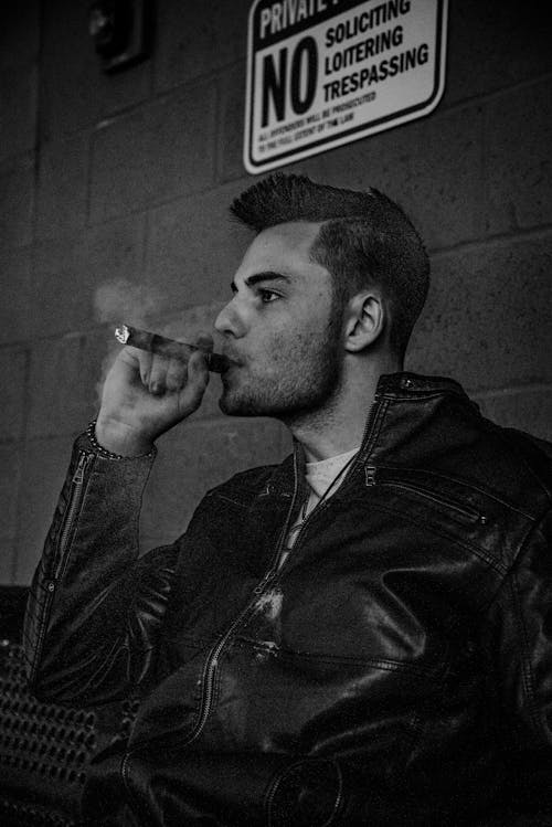 Man in Black Leather Jacket Smoking Cigarette