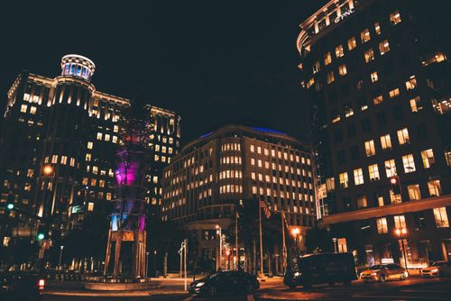 Free Dramatic cityscape at night with illuminated buildings and vibrant lighting in an urban setting. Stock Photo