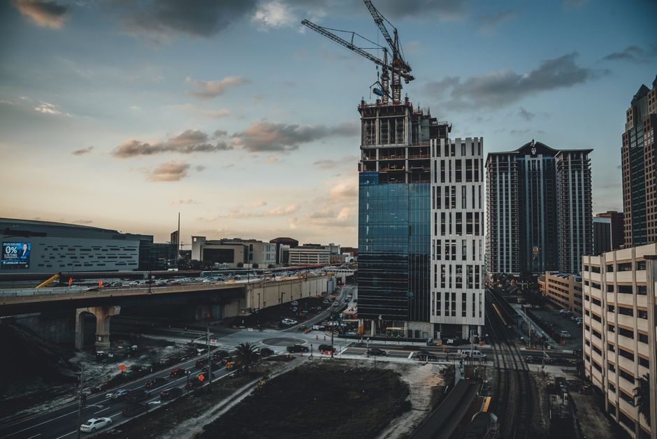 Unforgettable Family Pack Day/After-hours 31 Miles Helicopter Tour Theme Parks Review 2026 - Aerial view of urban construction in progress with a bustling cityscape at sunset.