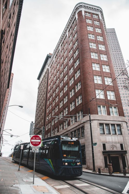 Free A tram passes by a historic building in downtown Atlanta, showcasing urban architecture. Stock Photo