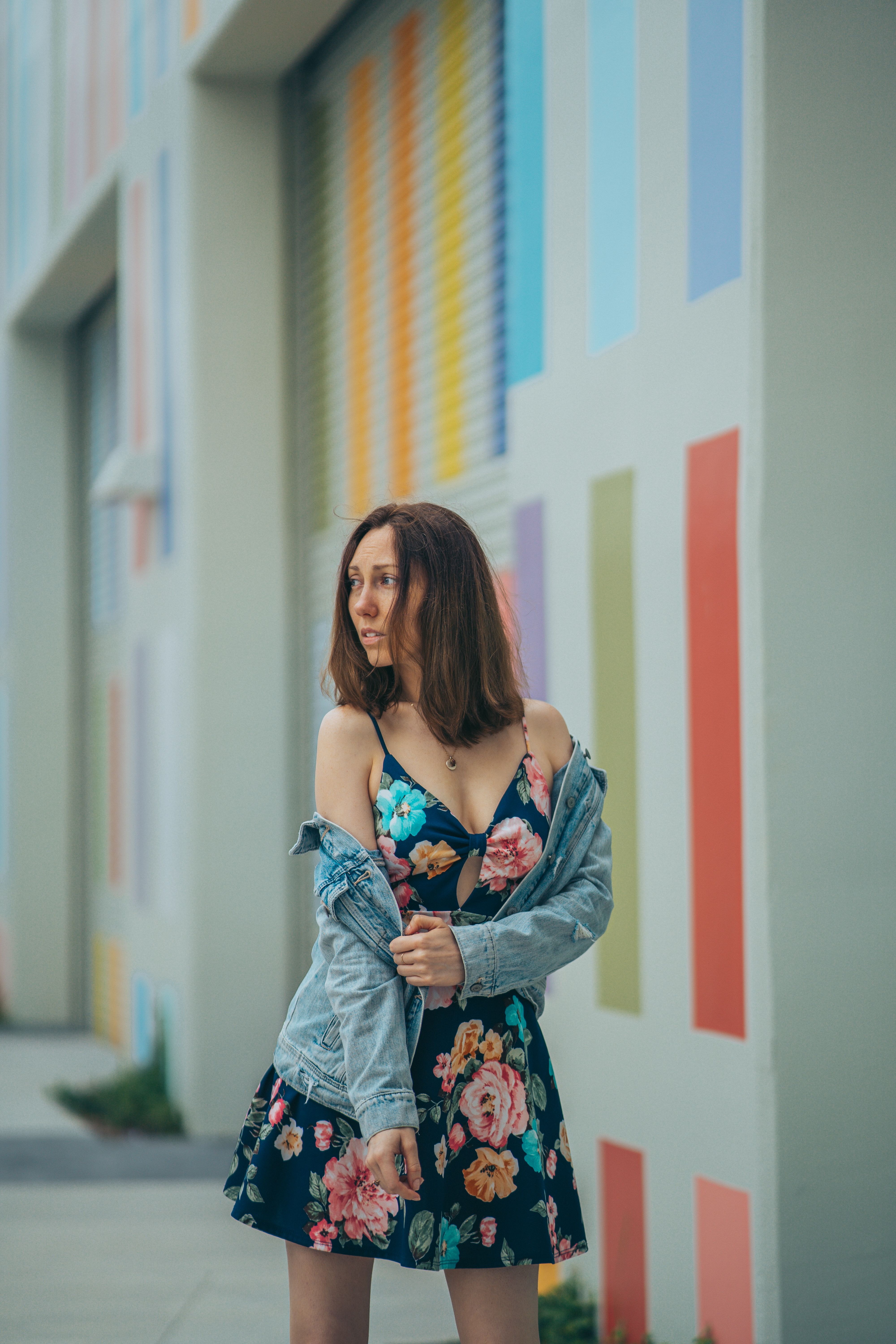 Woman wearing a floral sundress with a denim jacket