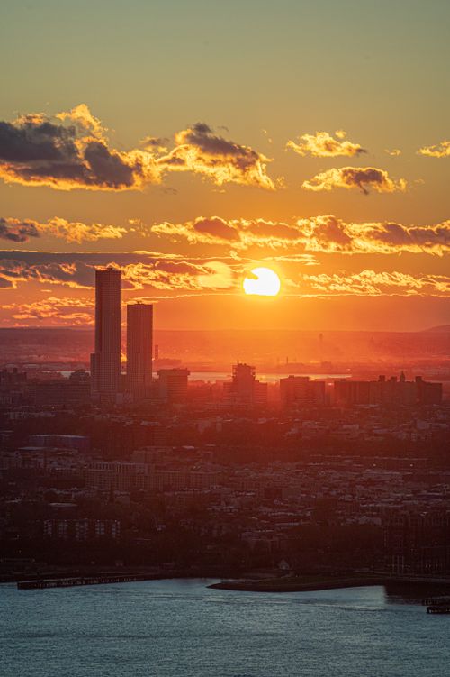 Free Captivating sunset over cityscape with skyscrapers and water view. Stock Photo