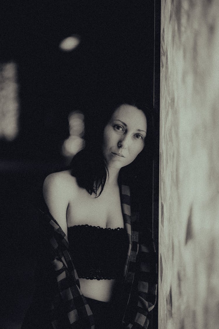 Black And White Portrait Of Woman Leaning Against Wall