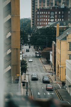 High-angle view of a busy urban street with traffic and tall buildings.