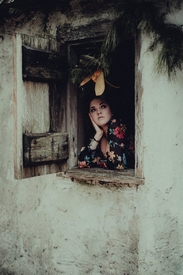 Woman Looking From Window In Old House