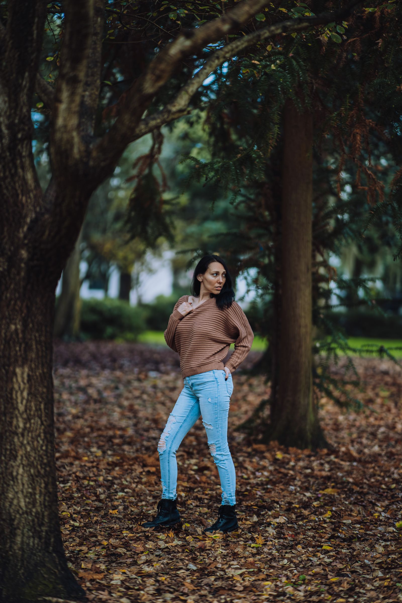 Woman wearing a brown crewneck sweater with mom jeans