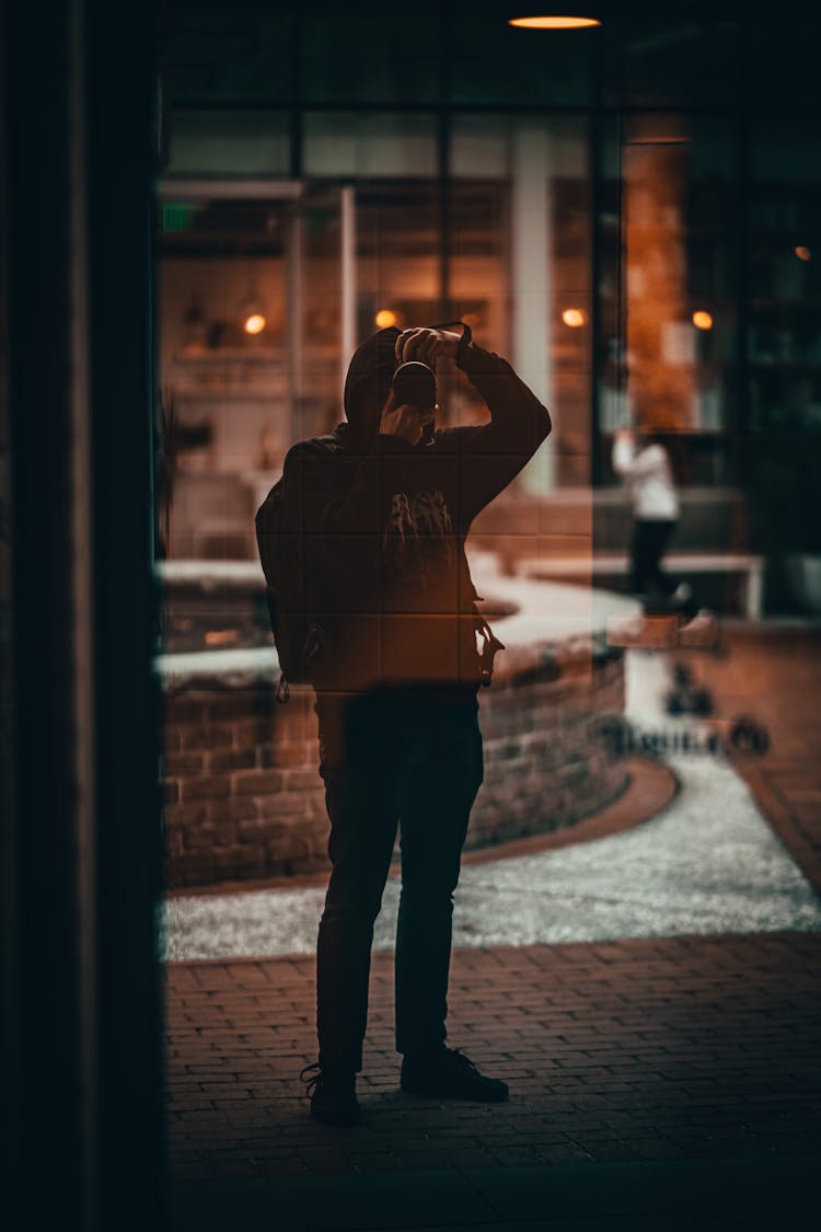 Unrecognizable Man In Hoodie Making Photo In Street