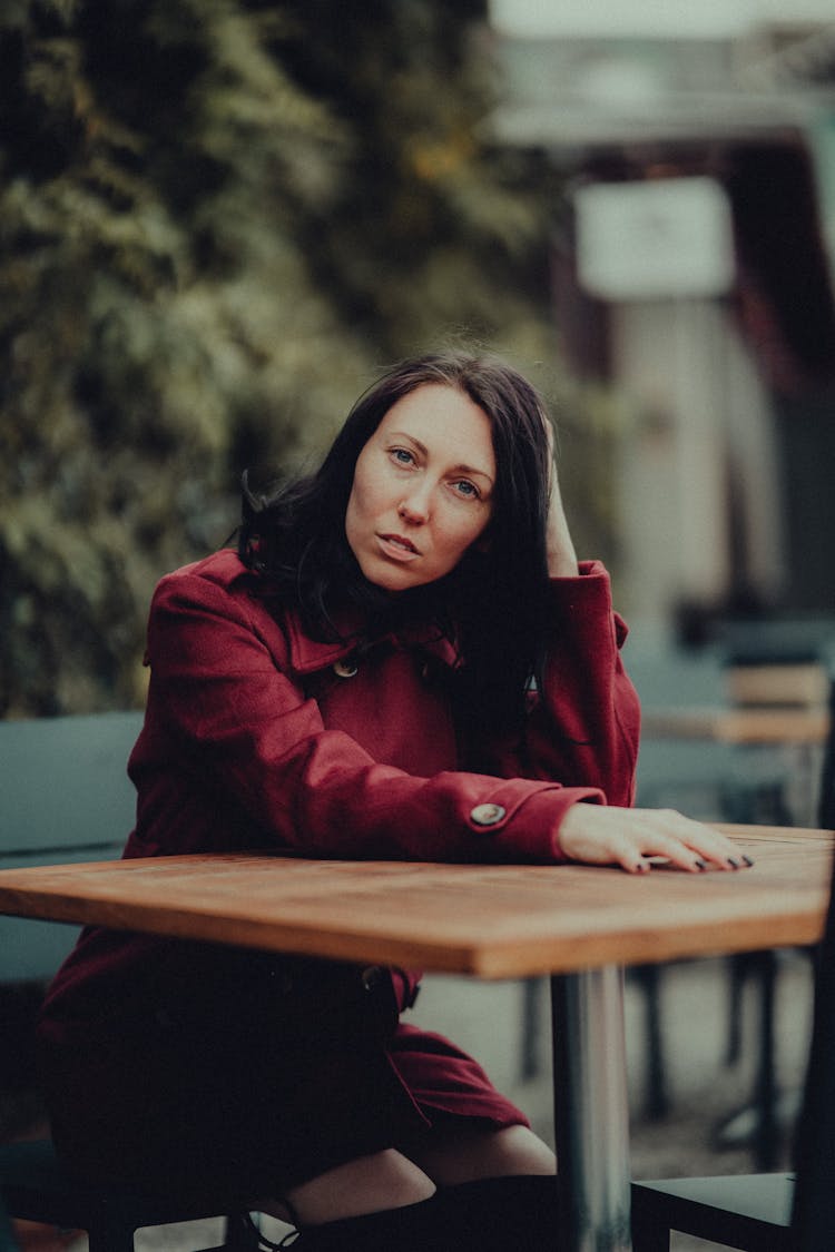 Woman Sitting At Table In Cafe