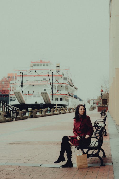 Woman Sitting on Bench in Port