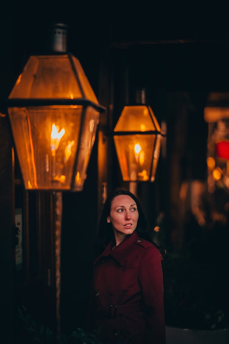 Woman Standing By Lit Lanterns At Night