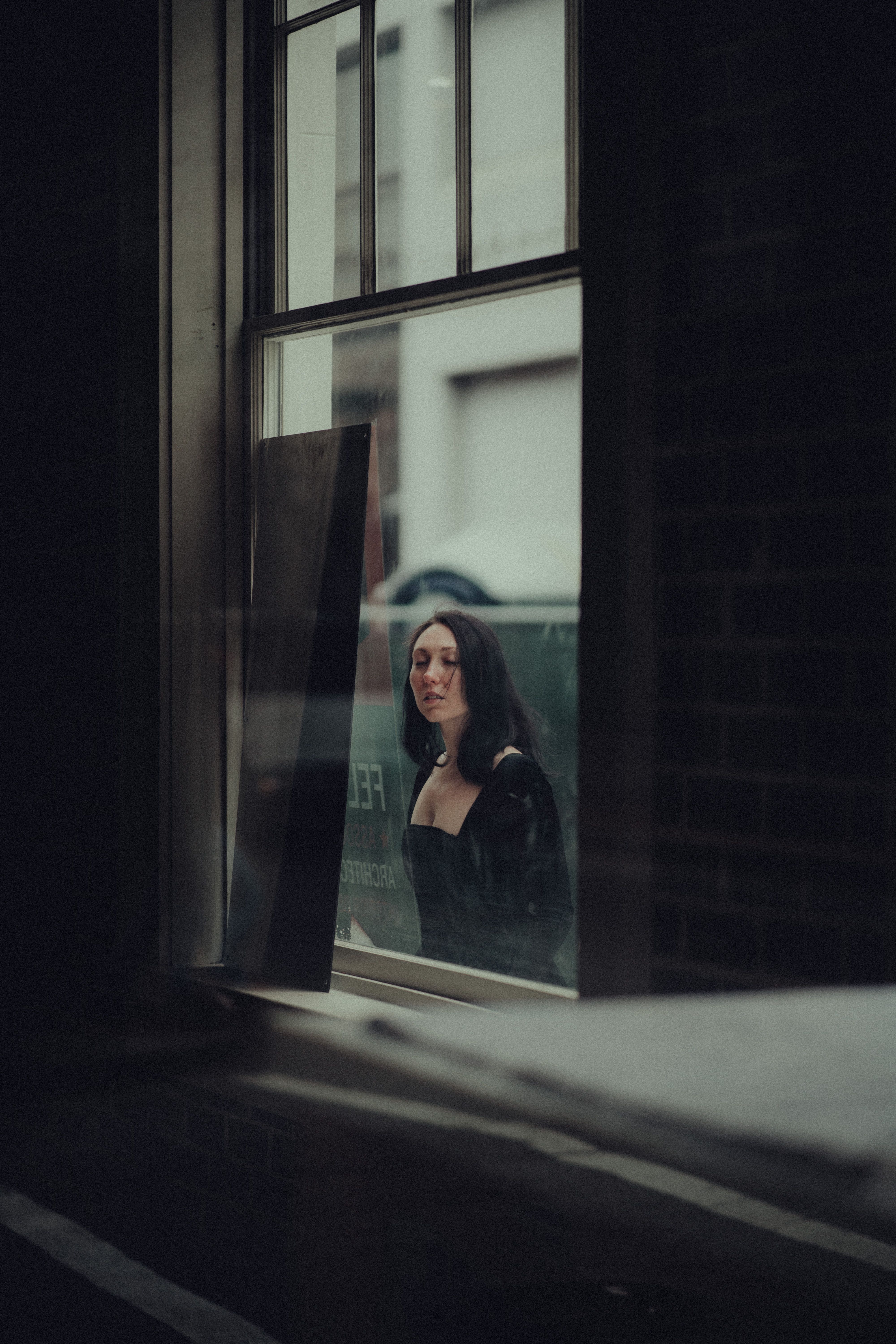 Woman in Black Long Sleeves Outside a Glass Window · Free Stock Photo