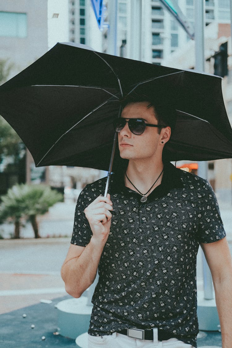 Adult Man In Sunglasses With Umbrella In City