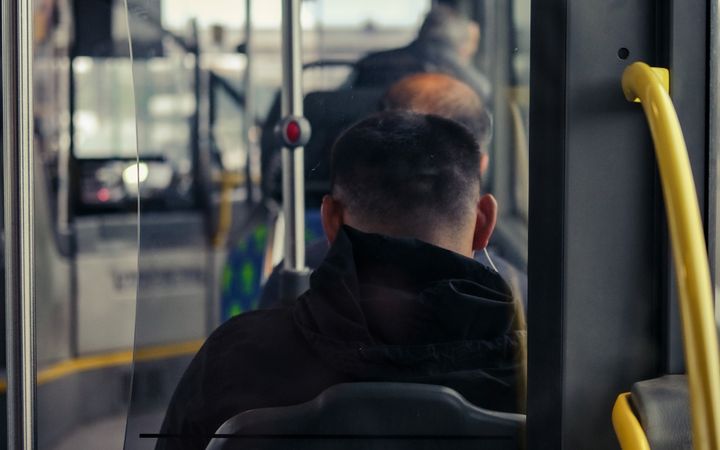 A view of commuters sitting inside a public bus, showcasing modern urban transportation.