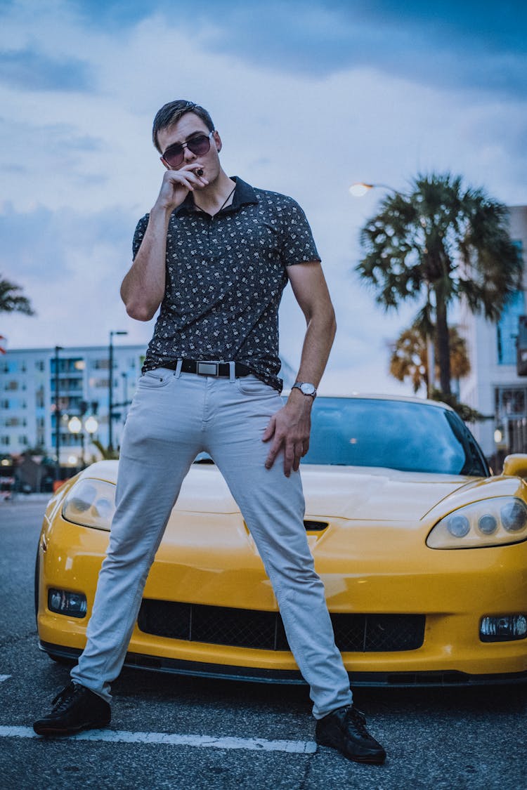 A Man Standing In Front Of A Car