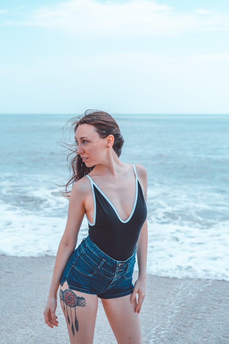 Woman In Shorts And Swimsuit Standing On Beach