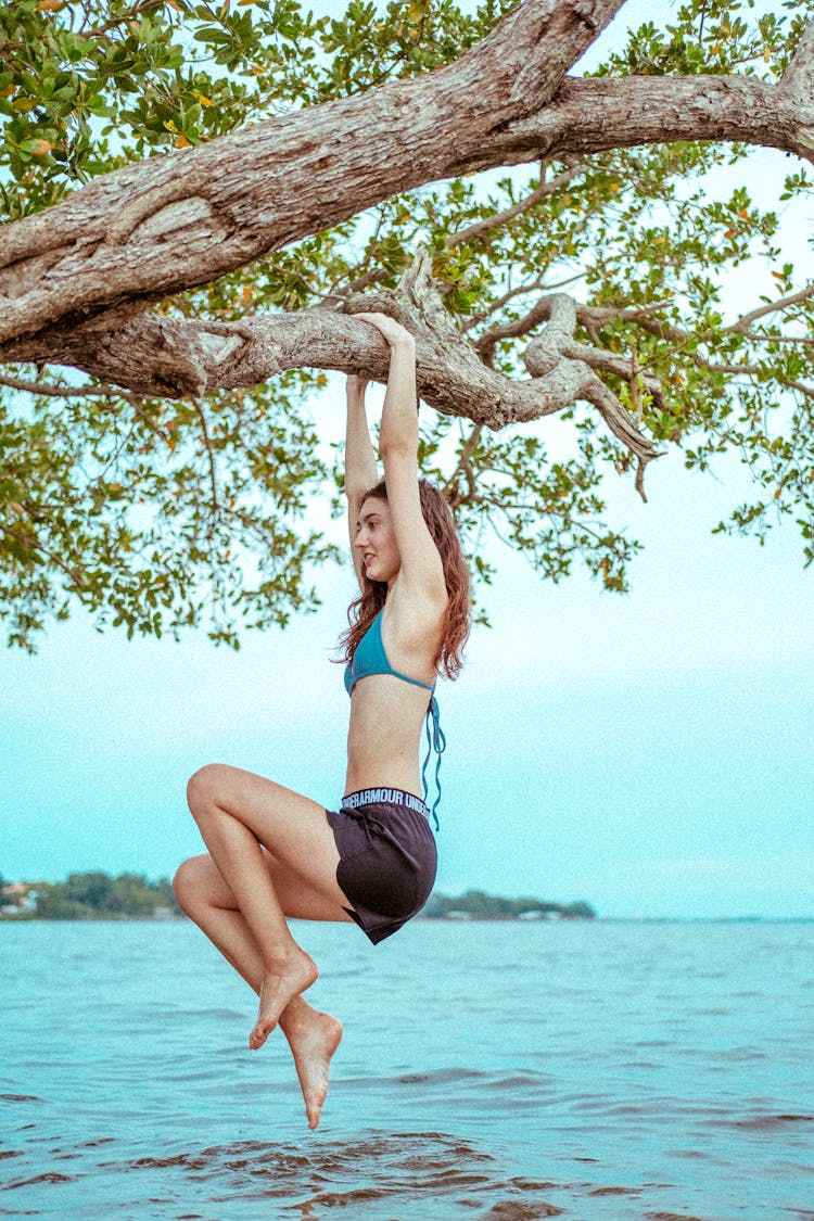 A Woman Hanging On A Tree Branch