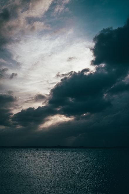 Storm cloud over a dark sea, photo by Connor Scott McManus on Pexels