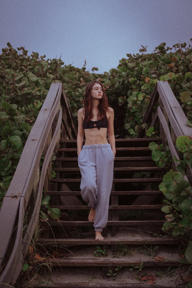 Woman In Bra And Pants Walking Down Steps