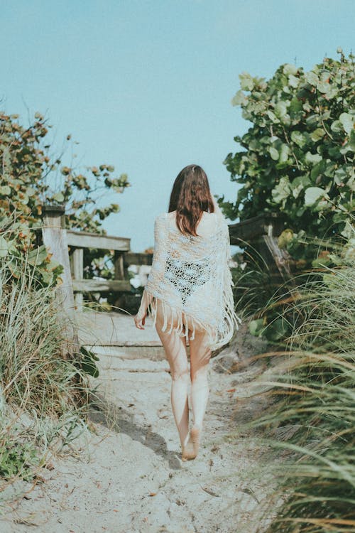 Woman Walking Through Sandy Path