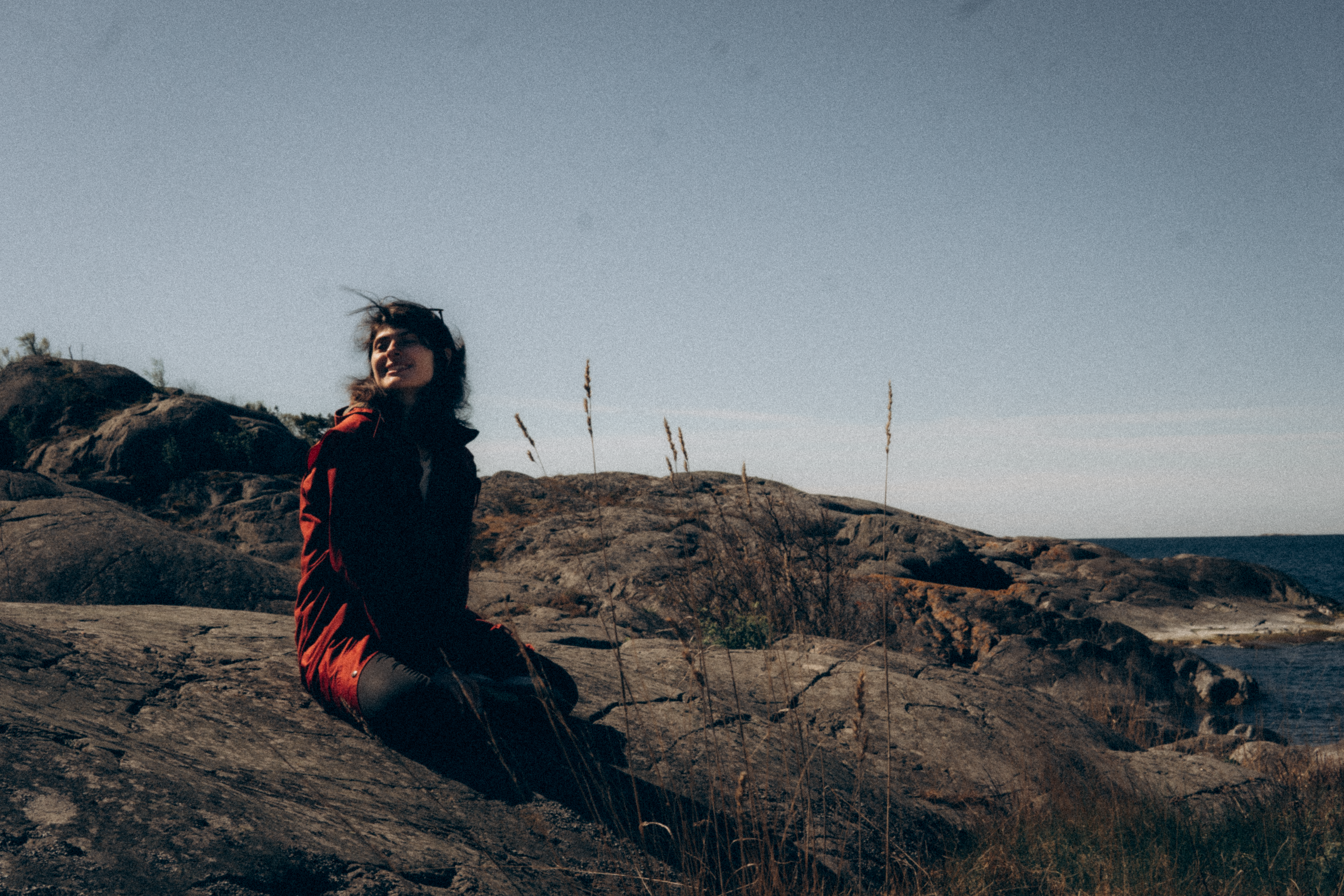 Woman Sitting on the Rocks by the Sea · Free Stock Photo